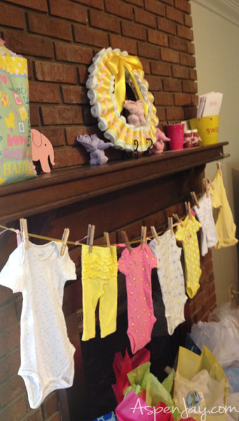 Baby shower mantle with diaper wreath and onesie banner. Great decorations which can then be given to the mama-to-be! 