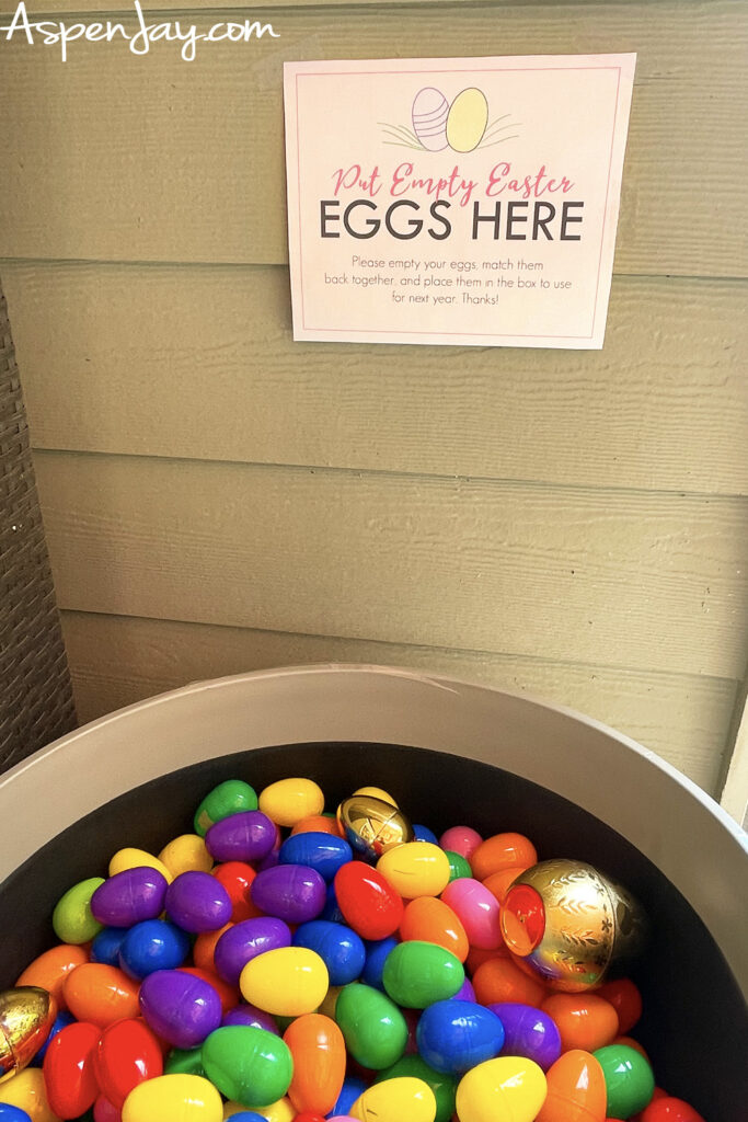 bin filled with plastic Easter eggs and sign that says put empty eggs here for easy cleanup