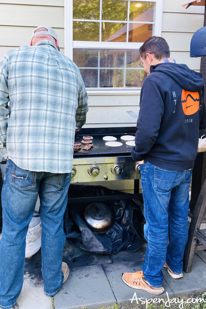 cooking pancakes on a griddle outdoors for Easter breakfast after egg hunt