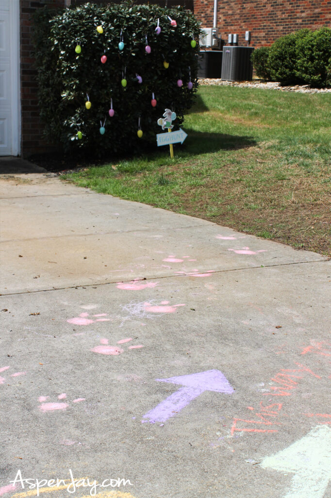 chalk bunny footprints and arrows leading to Easter egg hunt in driveway