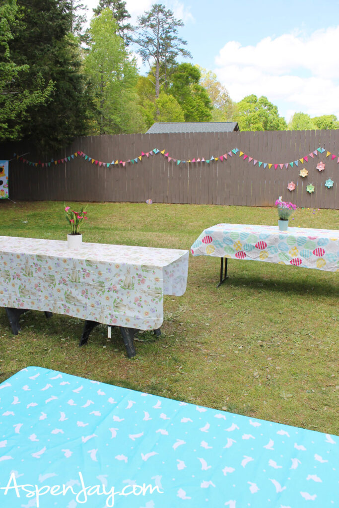 backyard Easter party setup with colorful spring banner and decorated tables