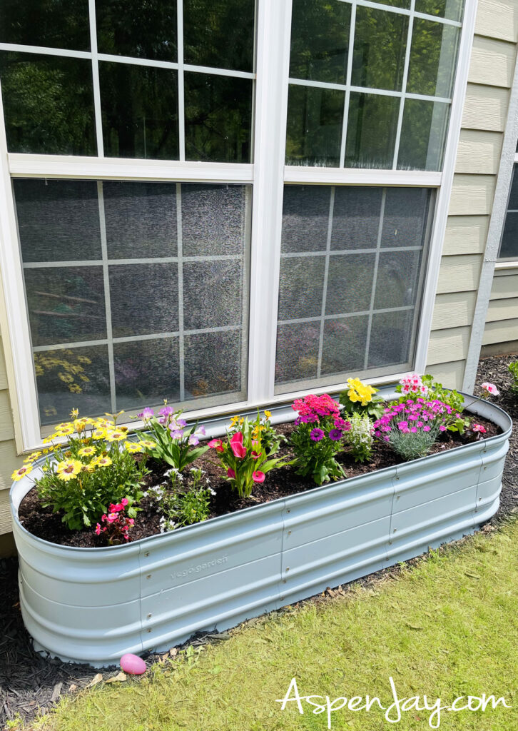raised garden bed with colorful spring flowers decorating backyard for Easter party