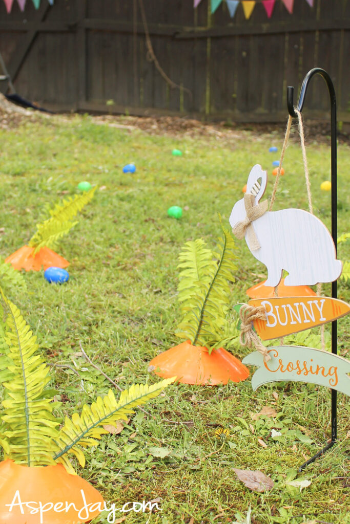 DIY carrot patch Easter yard decor using cones and greenery with bunny crossing sign